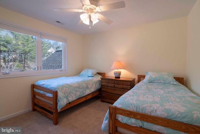 carpeted bedroom with a ceiling fan, visible vents, and baseboards