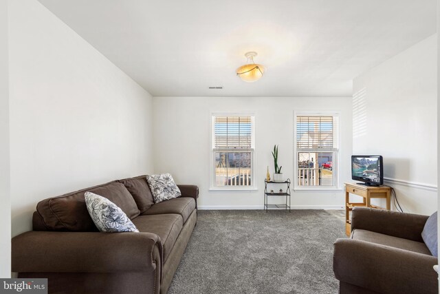 carpeted living room featuring visible vents and baseboards