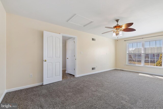 carpeted empty room featuring visible vents, attic access, and baseboards