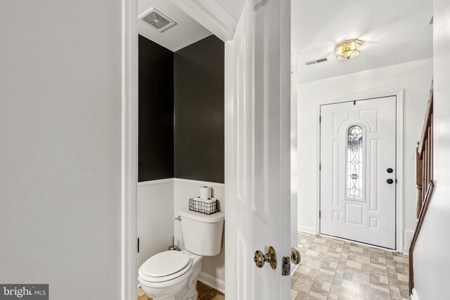 foyer featuring baseboards and visible vents