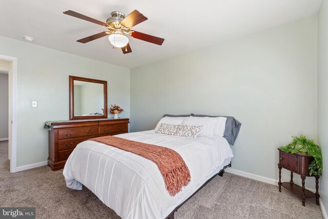 bedroom with light colored carpet, baseboards, and ceiling fan