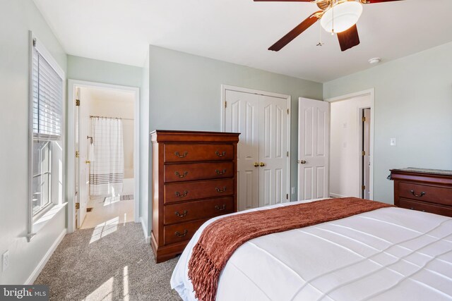 bedroom featuring a ceiling fan, carpet, baseboards, ensuite bath, and a closet