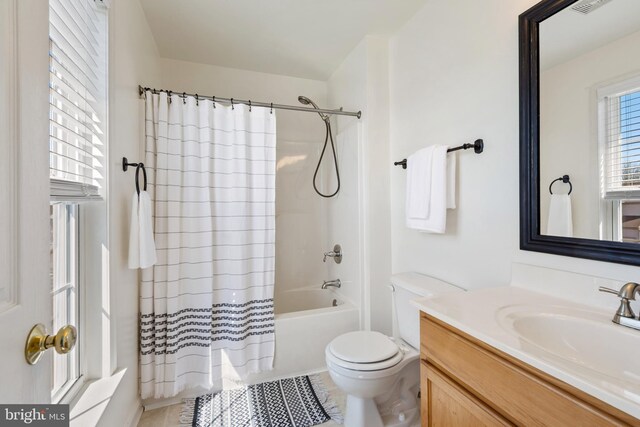 bathroom with a wealth of natural light, toilet, vanity, and shower / bath combination with curtain