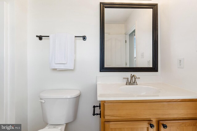 half bath featuring toilet and vanity