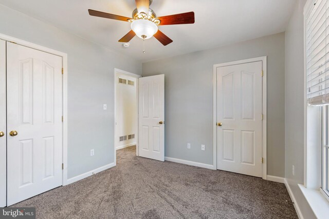 unfurnished bedroom with visible vents, carpet floors, baseboards, and ceiling fan