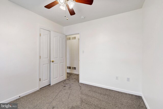 unfurnished bedroom featuring visible vents, ceiling fan, baseboards, and carpet