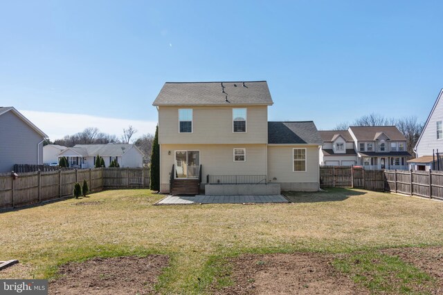 rear view of property featuring a fenced backyard, a residential view, a patio area, and a yard