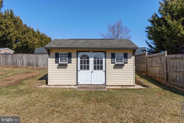 view of outbuilding with a fenced backyard and an outdoor structure