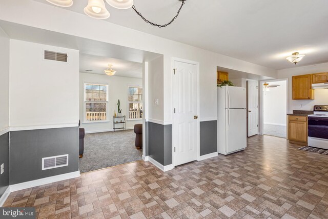 kitchen featuring white appliances, baseboards, visible vents, and ceiling fan