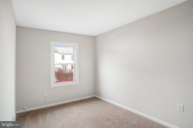 unfurnished room with carpet floors and baseboards