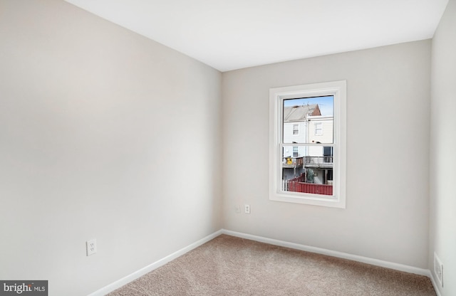 unfurnished room featuring carpet, visible vents, and baseboards