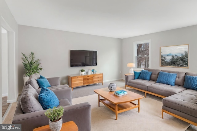 living room featuring light colored carpet and baseboards