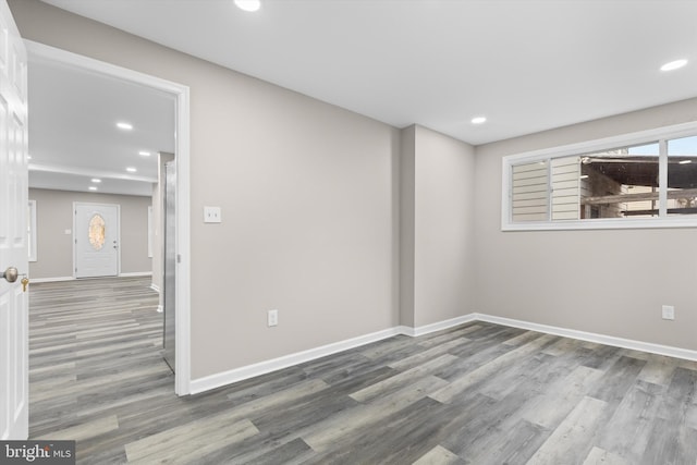 spare room featuring baseboards, wood finished floors, and recessed lighting