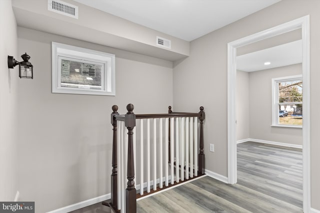 stairway featuring baseboards, visible vents, and wood finished floors