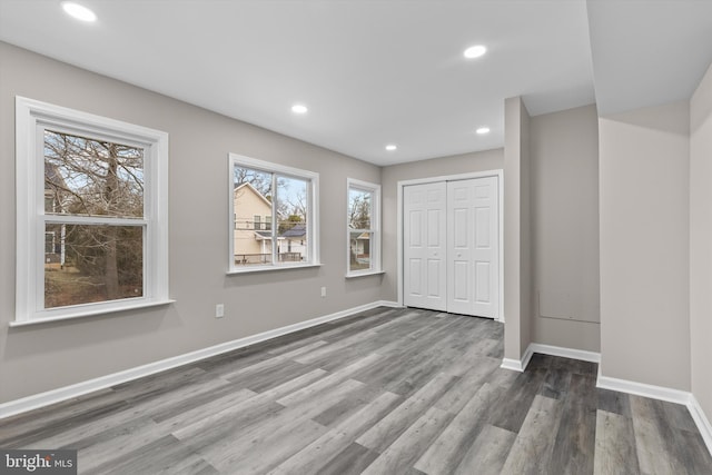 unfurnished bedroom featuring recessed lighting, wood finished floors, and baseboards