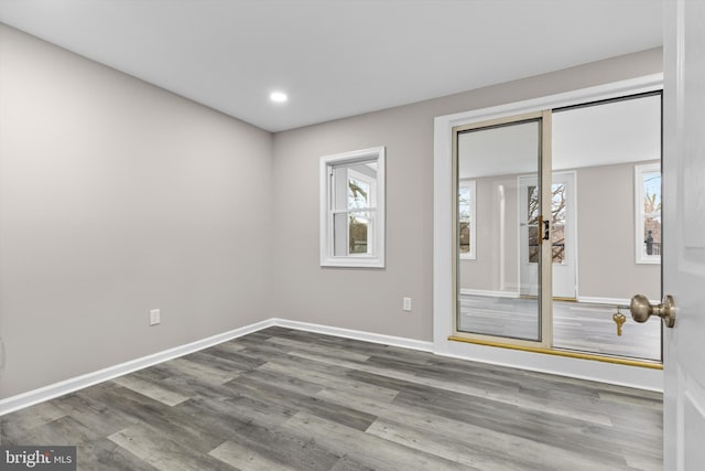 spare room with recessed lighting, baseboards, and wood finished floors