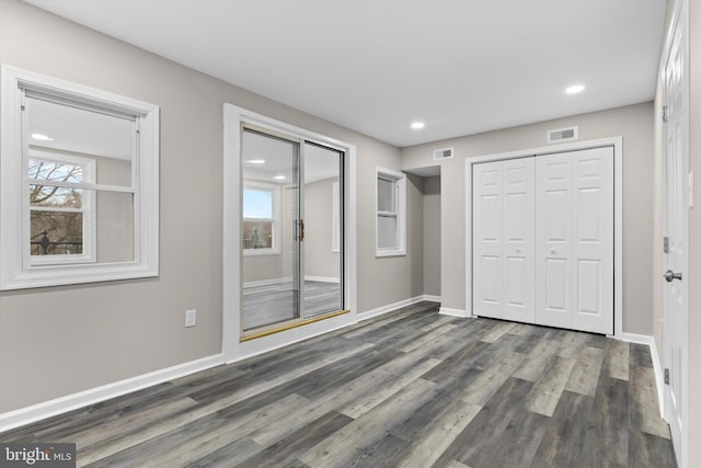 unfurnished bedroom with baseboards, visible vents, wood finished floors, and recessed lighting