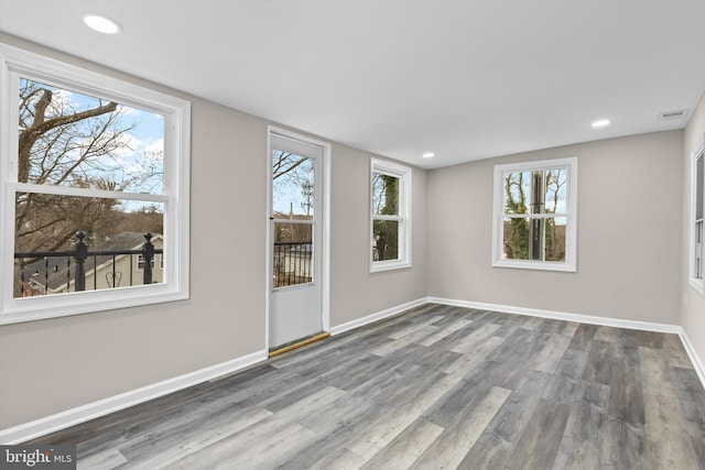 spare room with visible vents, baseboards, wood finished floors, and recessed lighting