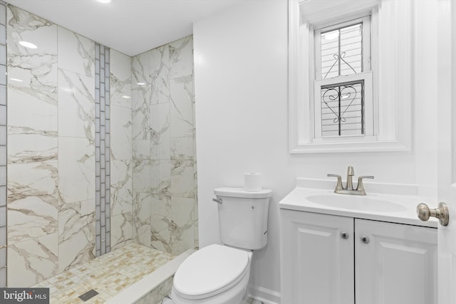 bathroom featuring a marble finish shower, baseboards, vanity, and toilet