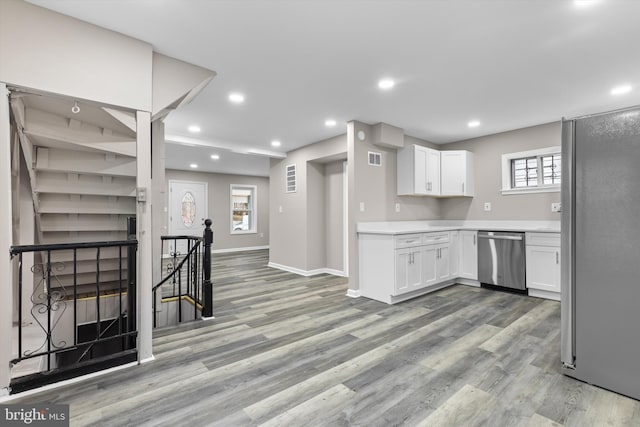 kitchen with light wood-style floors, appliances with stainless steel finishes, white cabinets, and recessed lighting