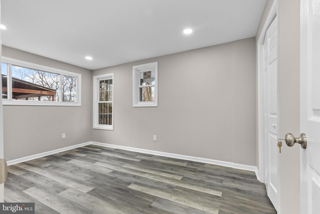 interior space with baseboards, wood finished floors, and recessed lighting