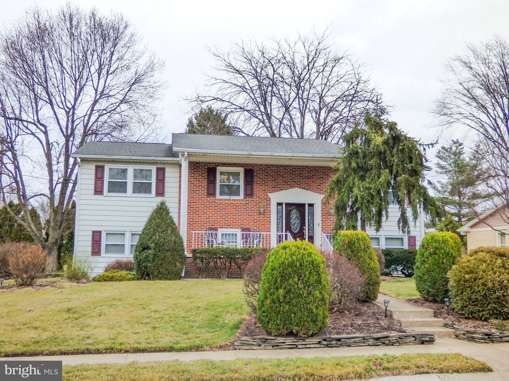 bi-level home featuring brick siding and a front lawn