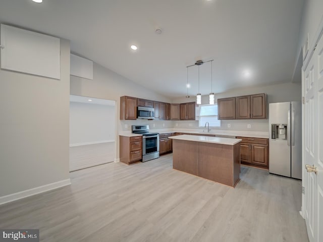 kitchen featuring a kitchen island, light countertops, lofted ceiling, light wood-style flooring, and appliances with stainless steel finishes