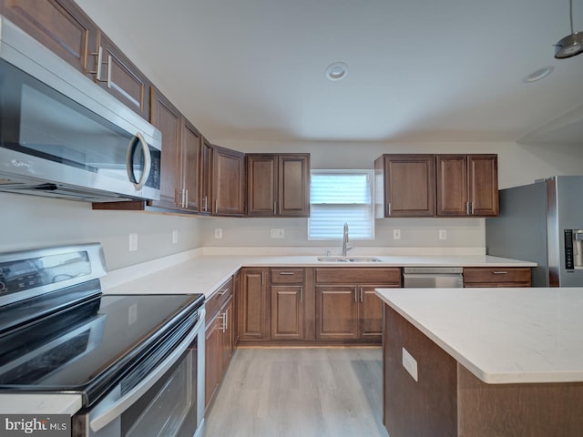 kitchen featuring a sink, light wood-style floors, appliances with stainless steel finishes, and recessed lighting