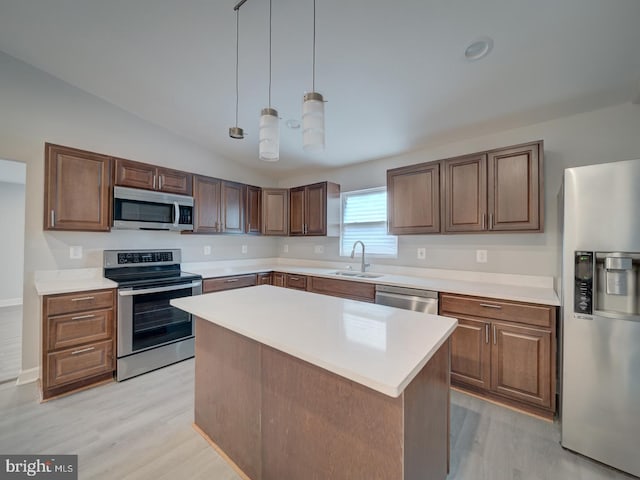 kitchen with light wood-style flooring, a sink, a kitchen island, stainless steel appliances, and light countertops