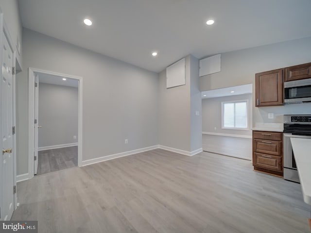 kitchen featuring light wood finished floors, baseboards, light countertops, recessed lighting, and stainless steel appliances