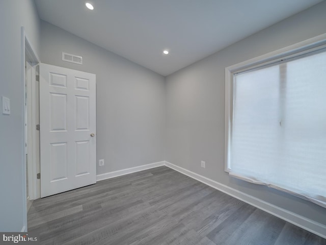 spare room featuring visible vents, recessed lighting, wood finished floors, and baseboards