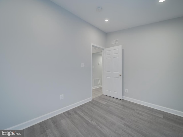 spare room featuring visible vents, baseboards, and wood finished floors