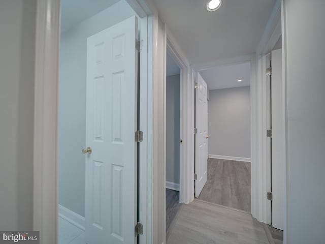 hall featuring recessed lighting, baseboards, and wood finished floors