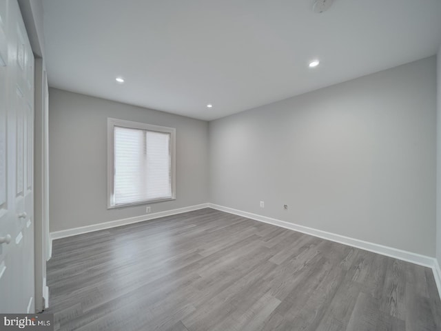 empty room with recessed lighting, baseboards, and dark wood finished floors