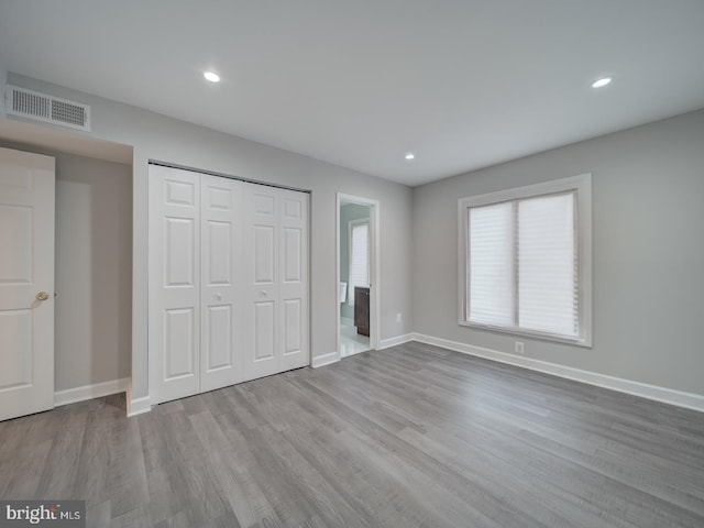 unfurnished bedroom with visible vents, recessed lighting, baseboards, and wood finished floors