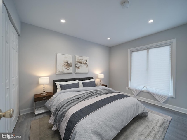 bedroom with a closet, recessed lighting, baseboards, and wood finished floors