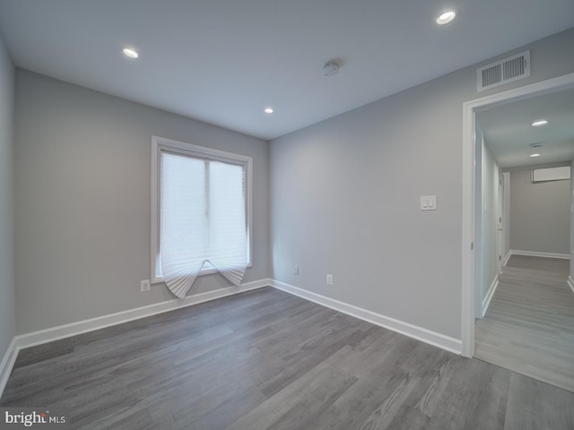 spare room with recessed lighting, wood finished floors, visible vents, and baseboards