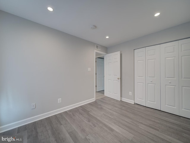 unfurnished bedroom featuring wood finished floors, recessed lighting, baseboards, and visible vents