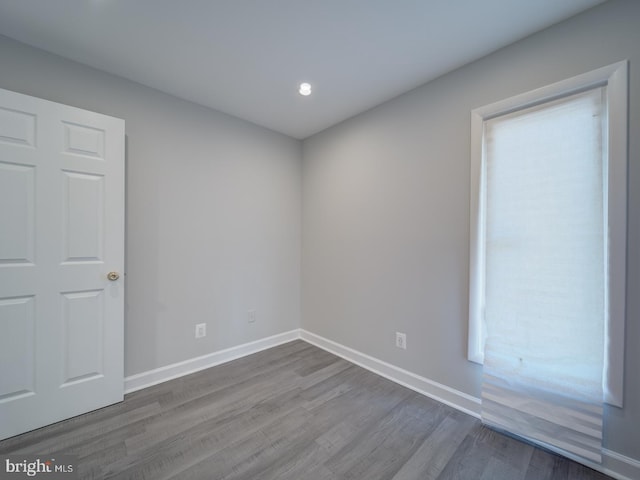 spare room with baseboards and dark wood finished floors