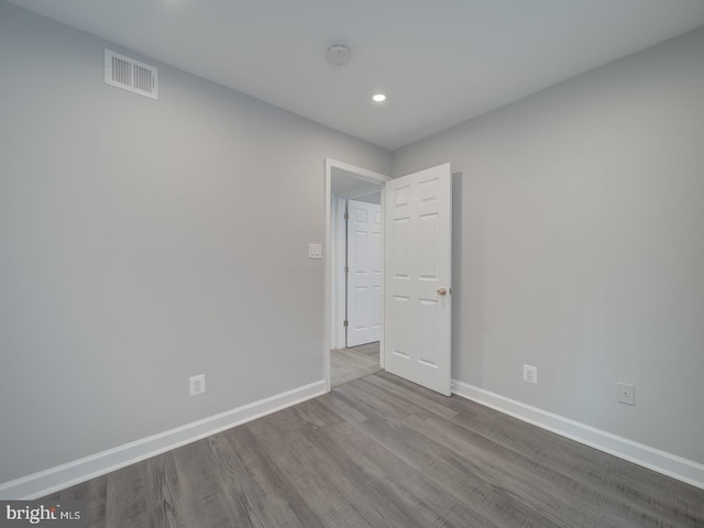 empty room with dark wood-type flooring, baseboards, and visible vents