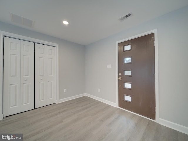 entrance foyer with baseboards, visible vents, and light wood-type flooring