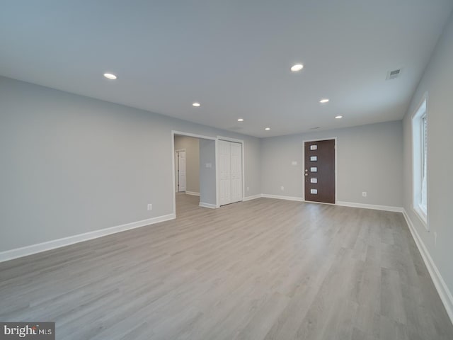 unfurnished room featuring light wood finished floors, visible vents, recessed lighting, and baseboards