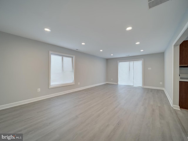 unfurnished living room with light wood-type flooring, visible vents, baseboards, and recessed lighting