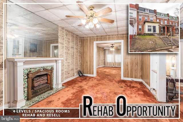 living room featuring baseboards, carpet flooring, a ceiling fan, and a tile fireplace