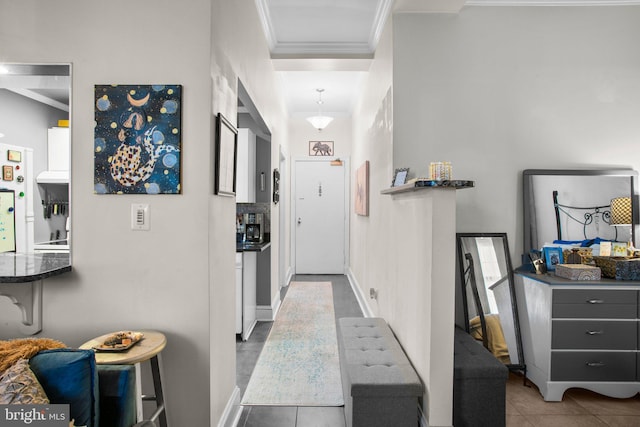 corridor with baseboards, ornamental molding, and tile patterned flooring