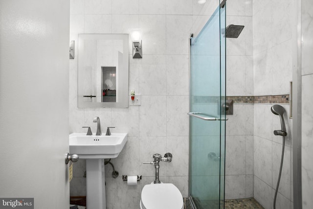 bathroom featuring a shower stall, toilet, and tile walls