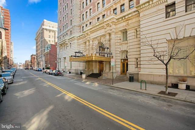 view of street with street lights, curbs, sidewalks, and entry steps