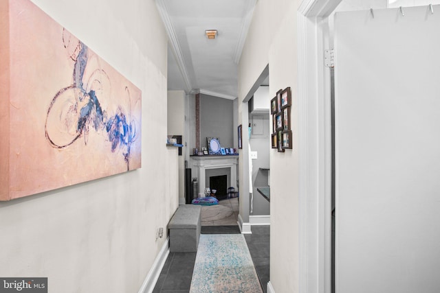 hall with baseboards, ornamental molding, and tile patterned flooring