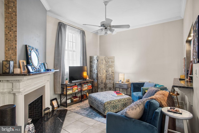 tiled living room featuring a fireplace, a ceiling fan, and ornamental molding