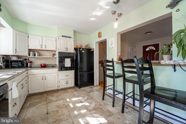 kitchen featuring white cabinets, light stone counters, black appliances, open shelves, and backsplash